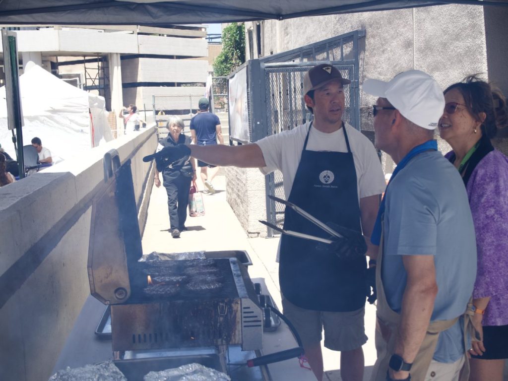 Temple volunteers prepare teriyaki burgers.