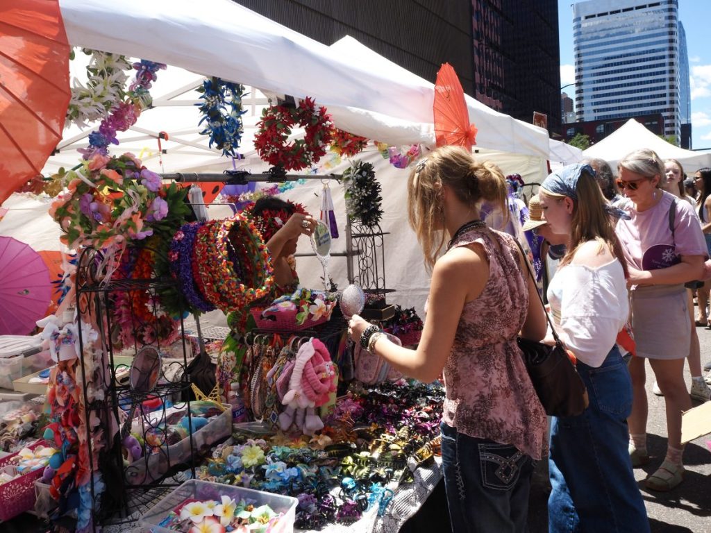 A vendor holds up a mirror for a customer.