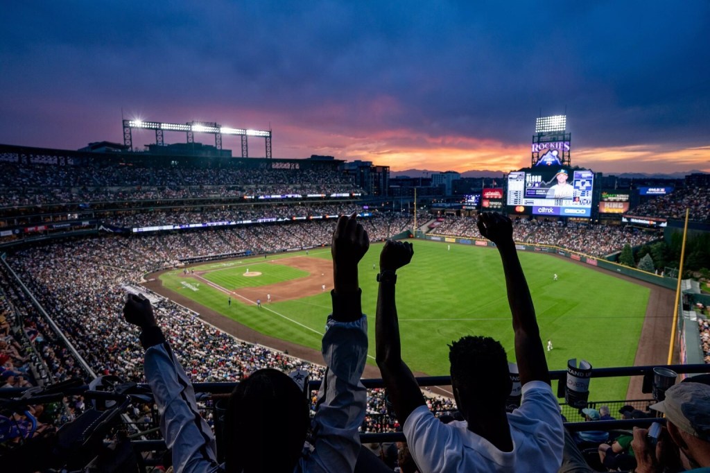 Fans cheering during an evening Rockies game