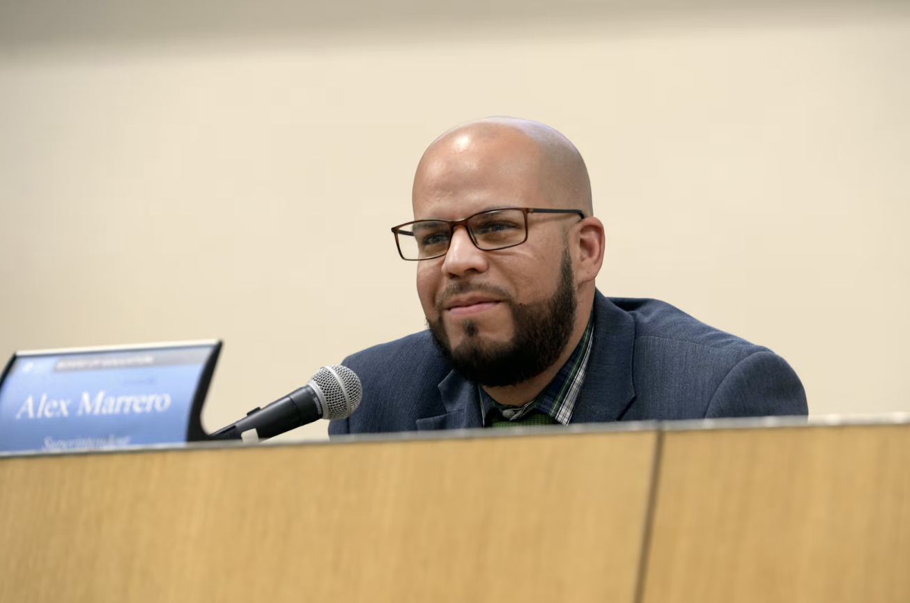 Denver Public Schools Superintendent Alex Marrero listens to students at a school board meeting
