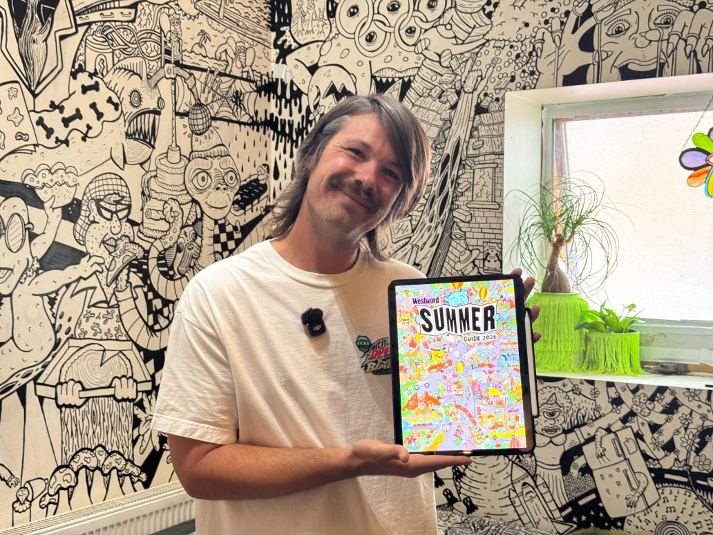 man holding cover of issue he illustrated