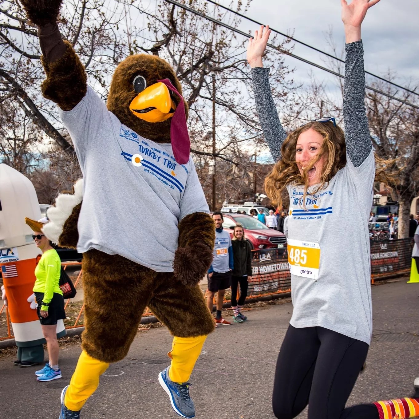 a person jumps with a guy in a turkey costume