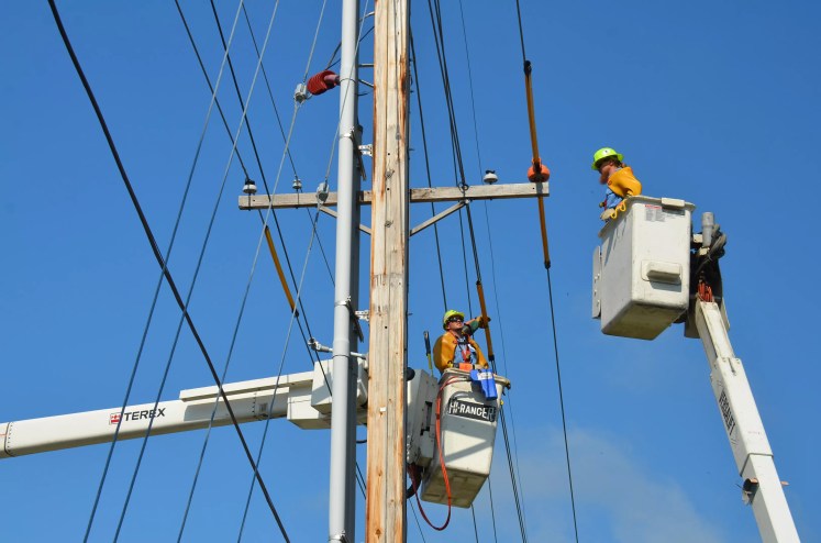 Workers up on an electric pole.