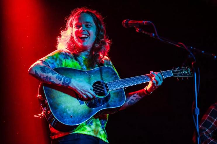 man in tiedye playing guitar
