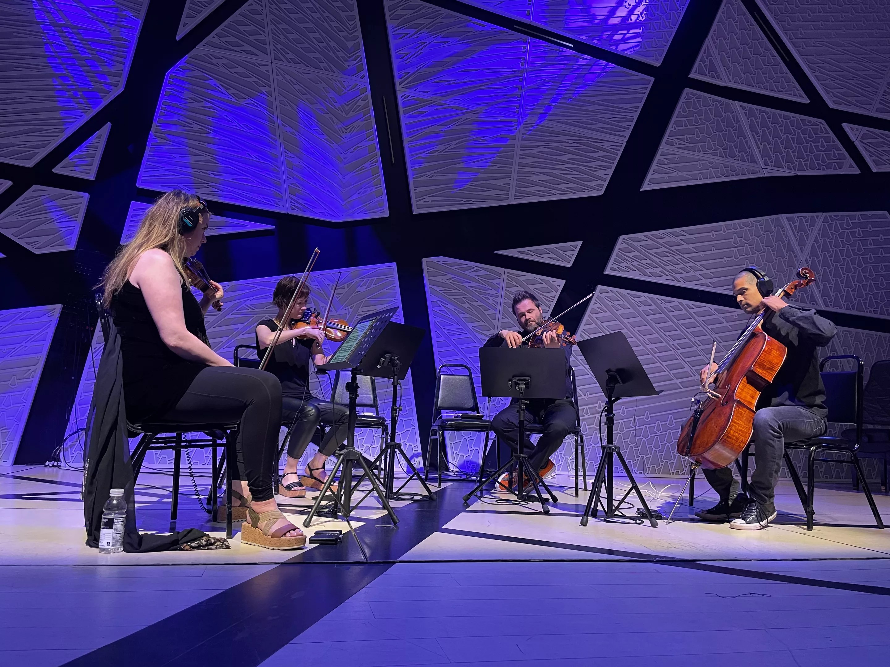 a string quartet performs amid blue lighting
