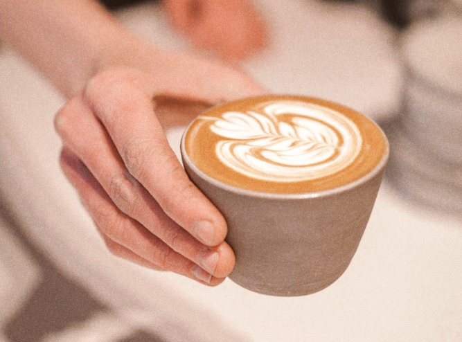 a hand holding a latte