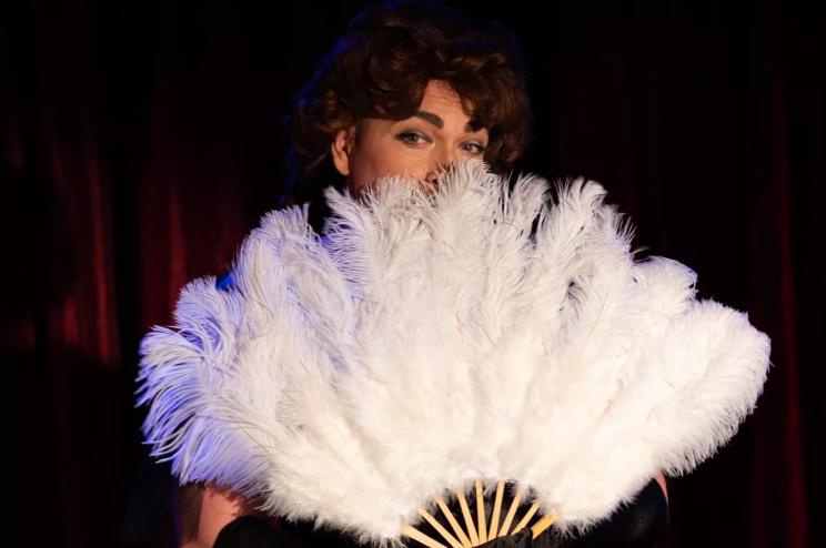 Jeremy Rill in drag with fan