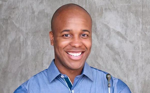 smiling man in a blue collared shirt