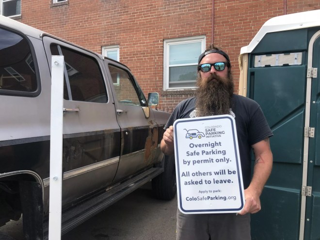 Matt Lash standing in front of his car at the safe parking area he manages.