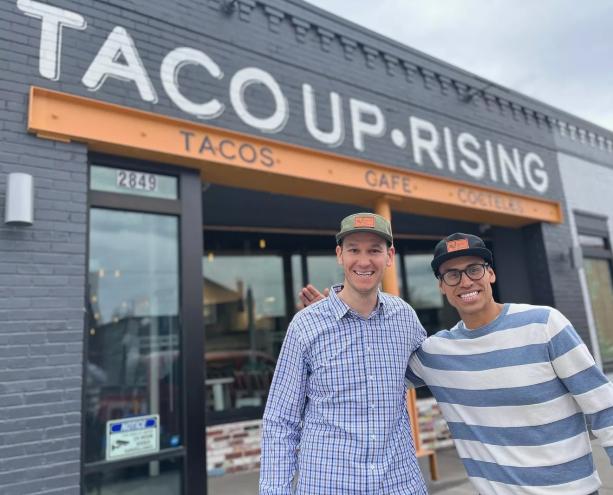 two men standing in front of a building