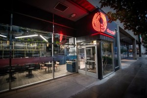 the exterior of a club with red lettering spelling "dazzle."