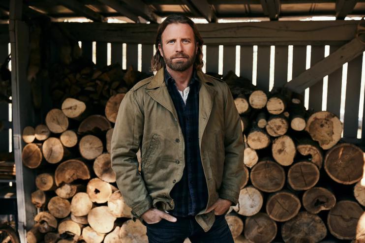 man standing in front of logs