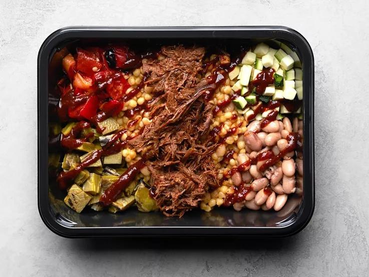 black container with beans and food and bison on white table