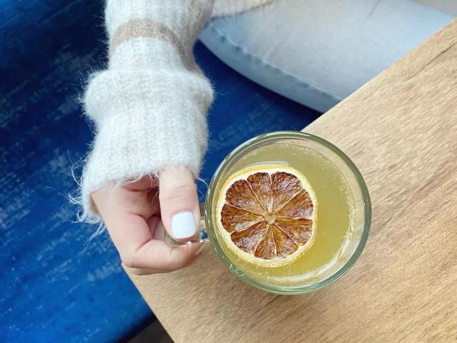 hand holding a drink in a clear mug