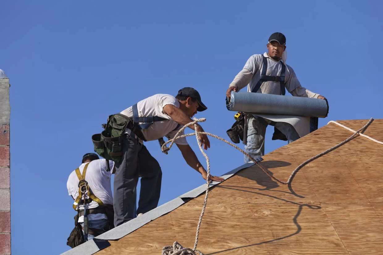 three men working on roof.