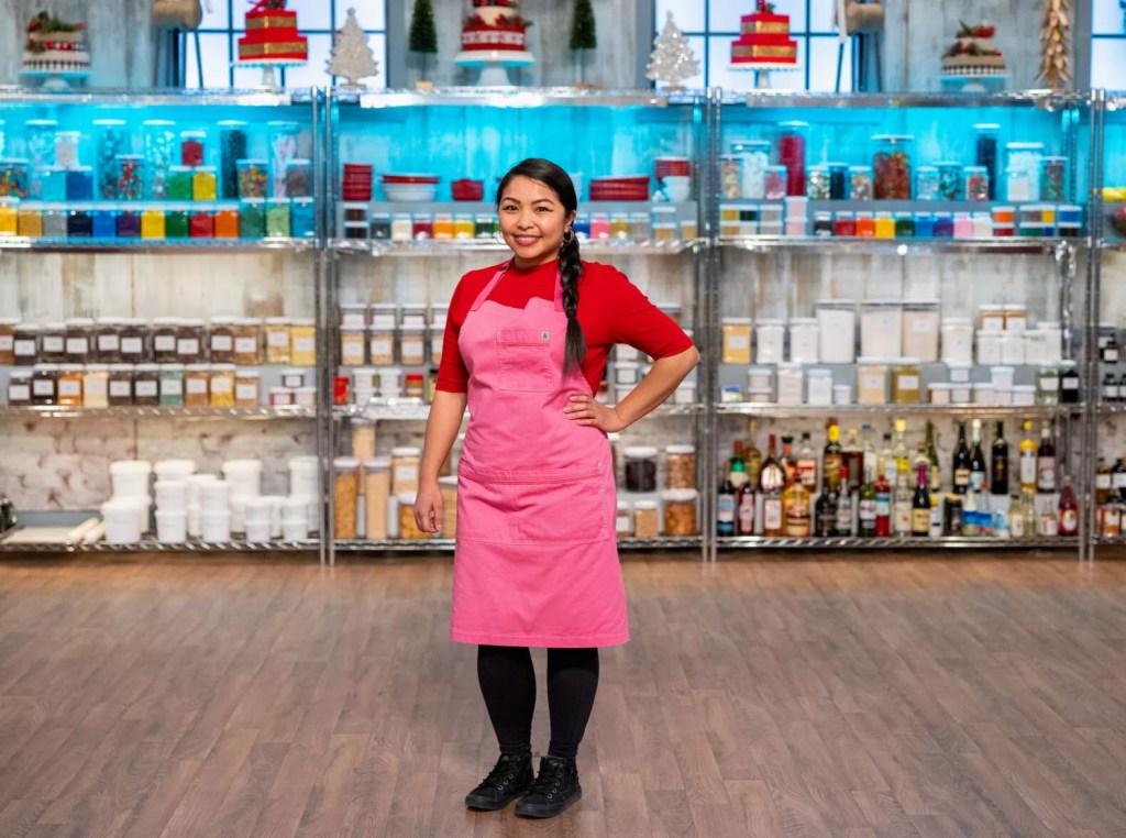 a woman posting in a red shirt and pink apron