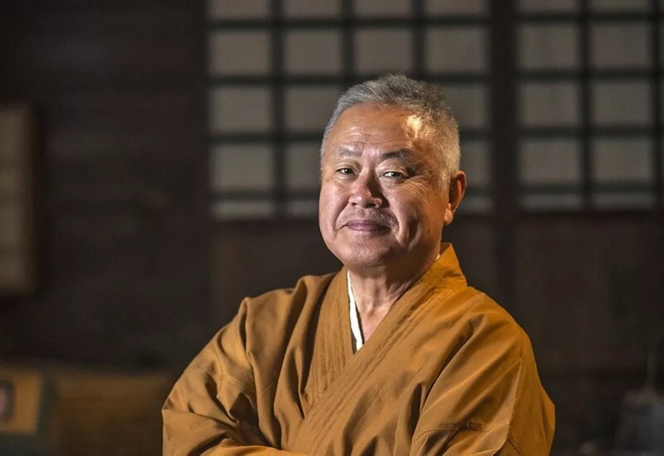 Man in Japanese outfit at restaurant.