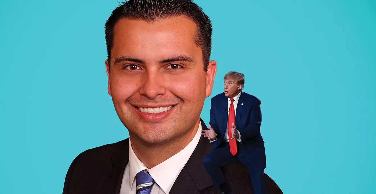 man in suit with Trump on his shoulder.