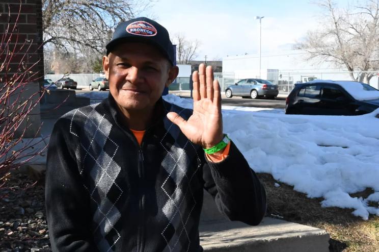 A migrant waves hi.