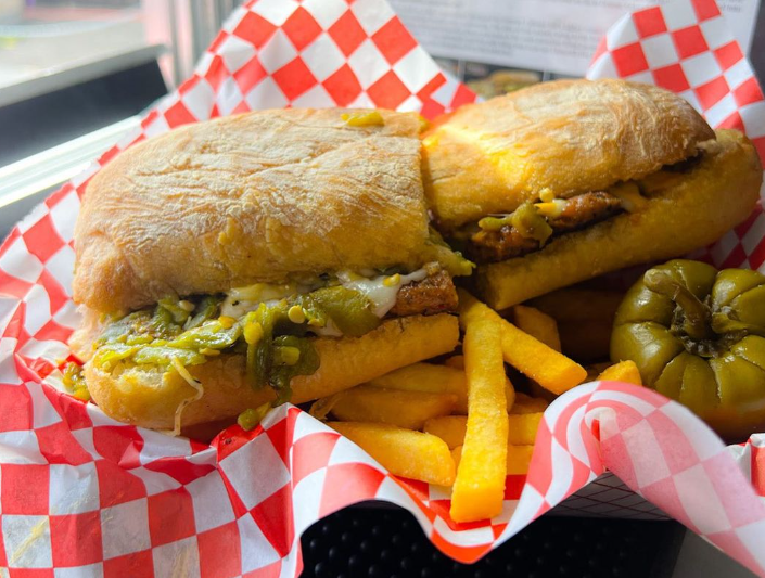 an Italian sausage sandwich with green chiles