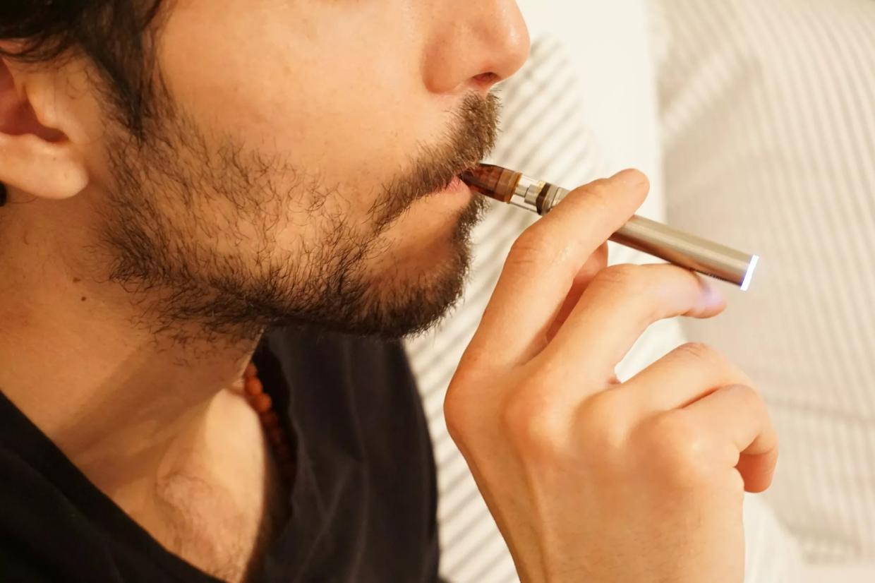 Man hits a cannabis vape pen