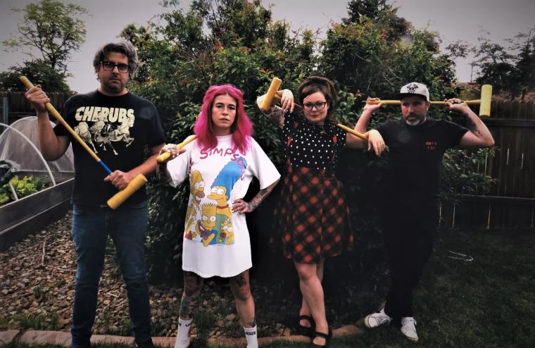 two men and two women standing in a yard