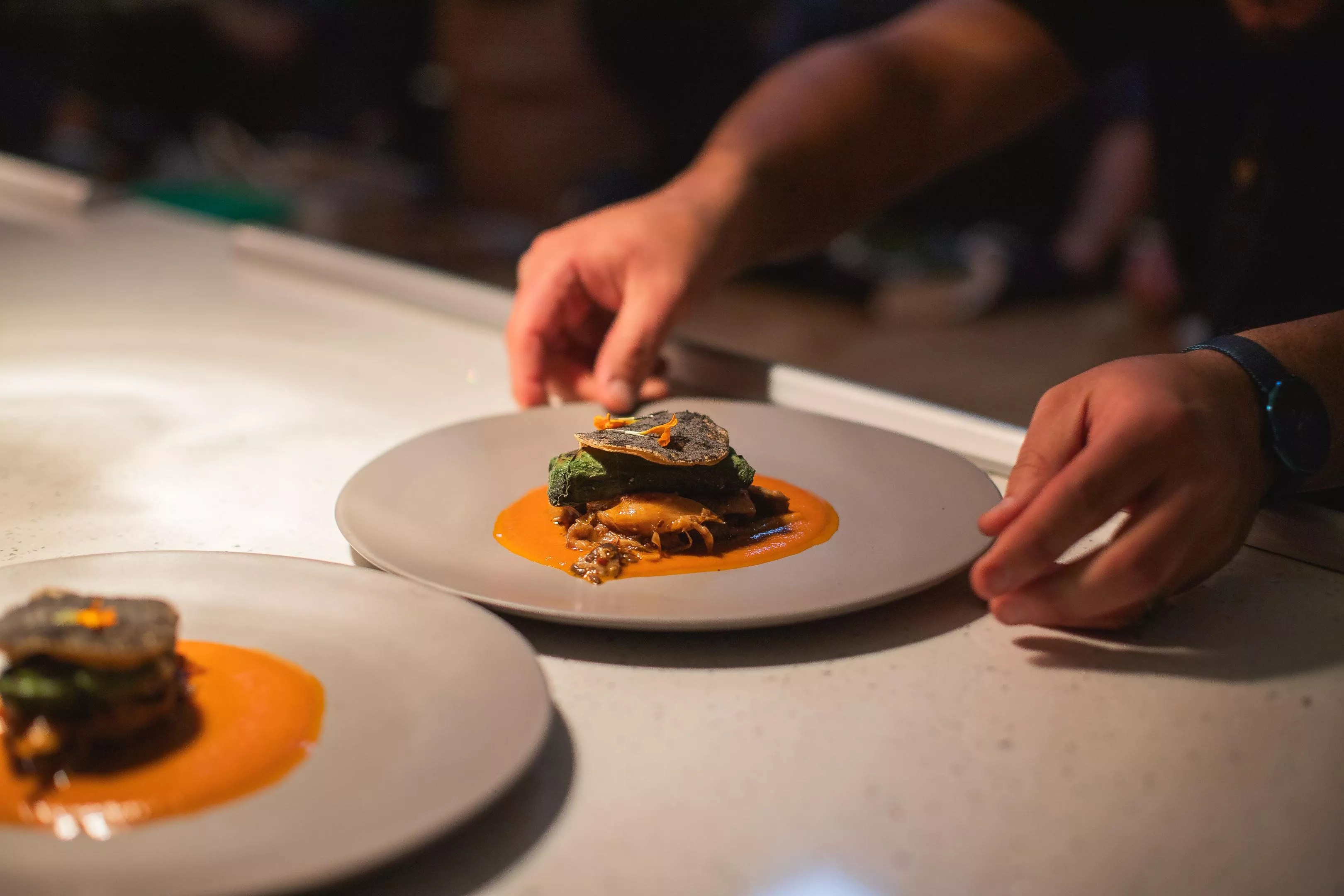 hands reaching for a plate