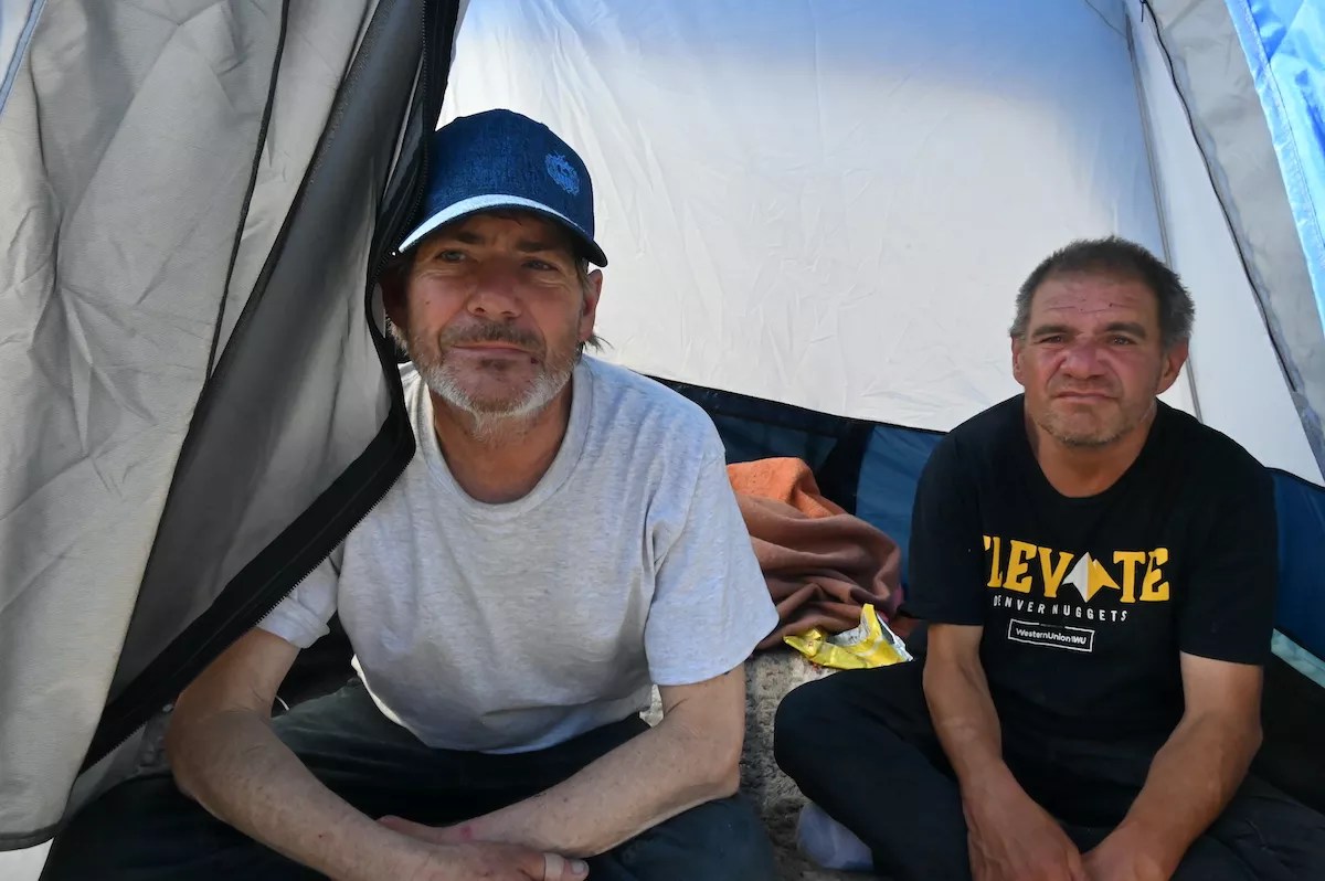 Two homeless residents sit in their tent in Denver.