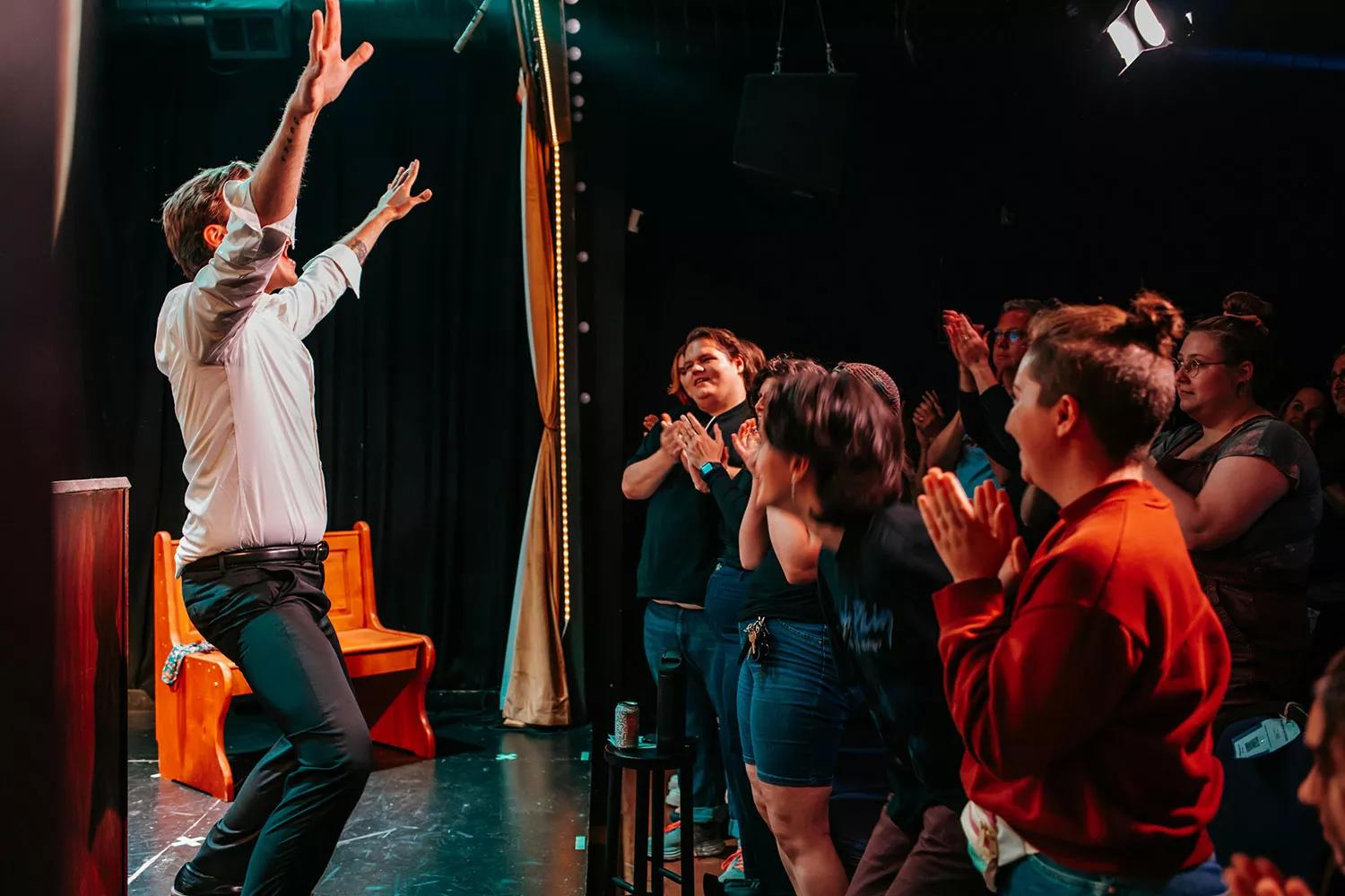 actors on stage and audience clapping