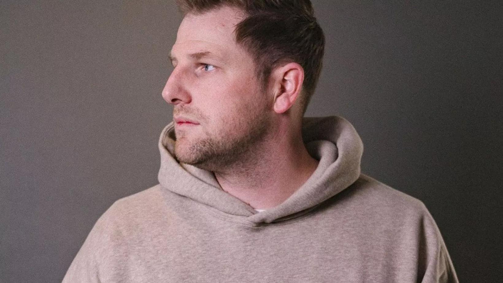 man in a tan sweatshirt