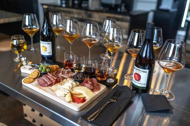 Charcuterie board along with cider and glassware.