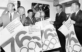 men in suits in 1970 with Olympics sign