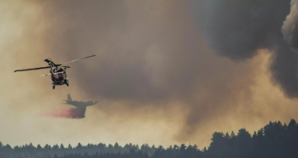 Air tanker and helicopter drop water and spray on fire
