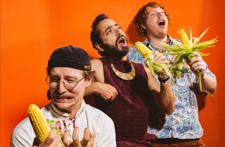 three men holding corn