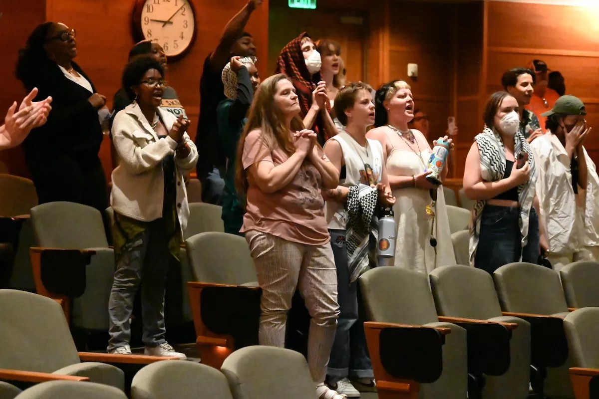 Protesters chant in the city council chambers.