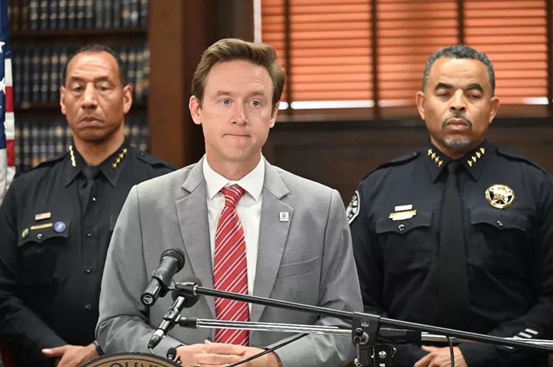man in suit by police officers