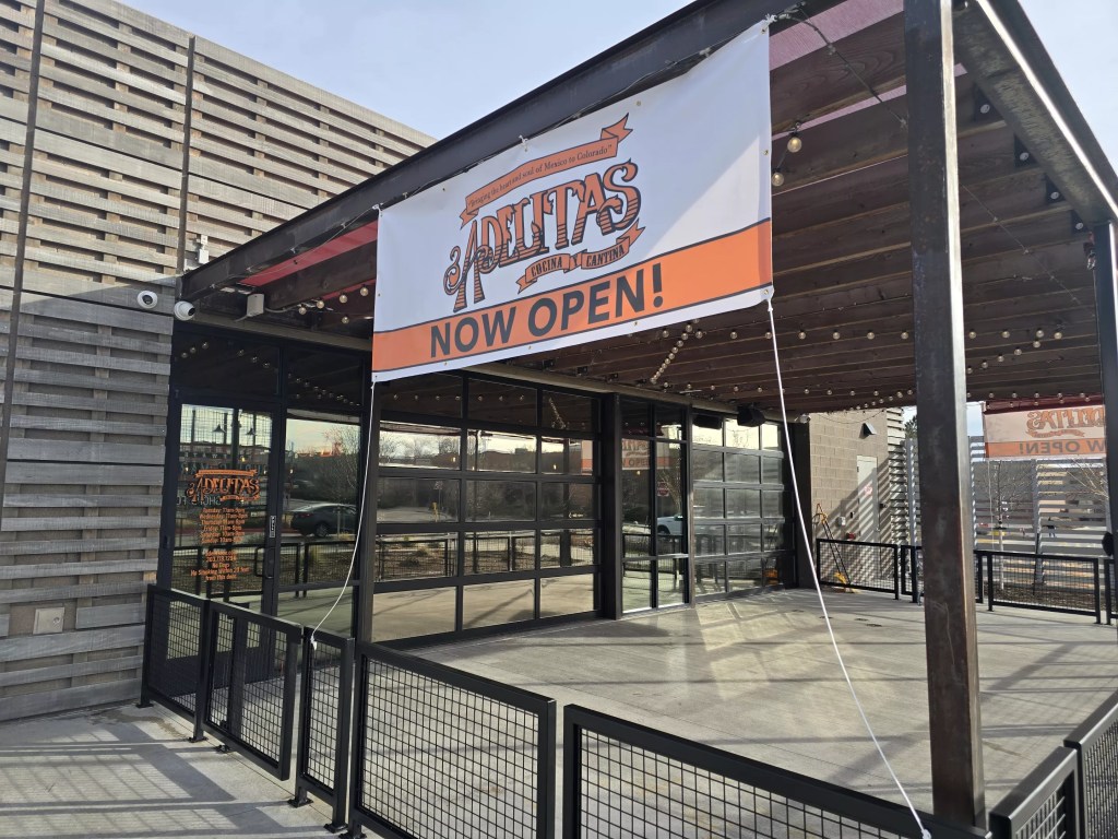 "now open" sign on a building