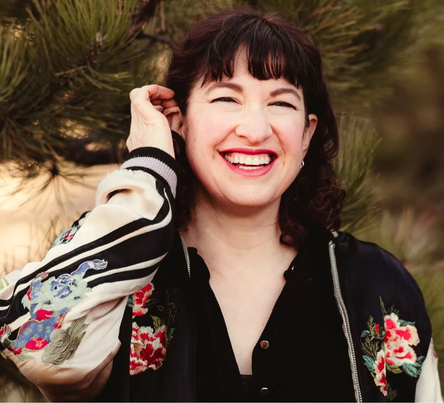 woman in flowered baseball jacket