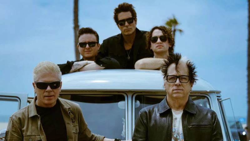 Members of The Offspring pose on a car
