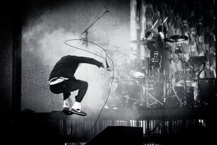 member of Deftones jumping on stage with a microphone
