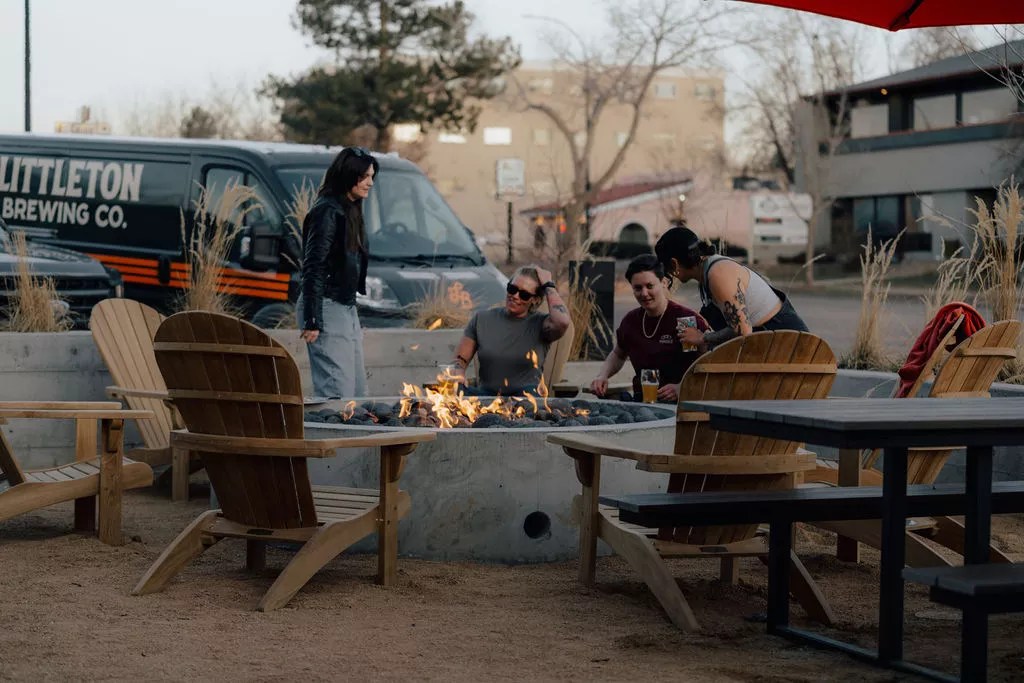People standing around a fire at a brewery.