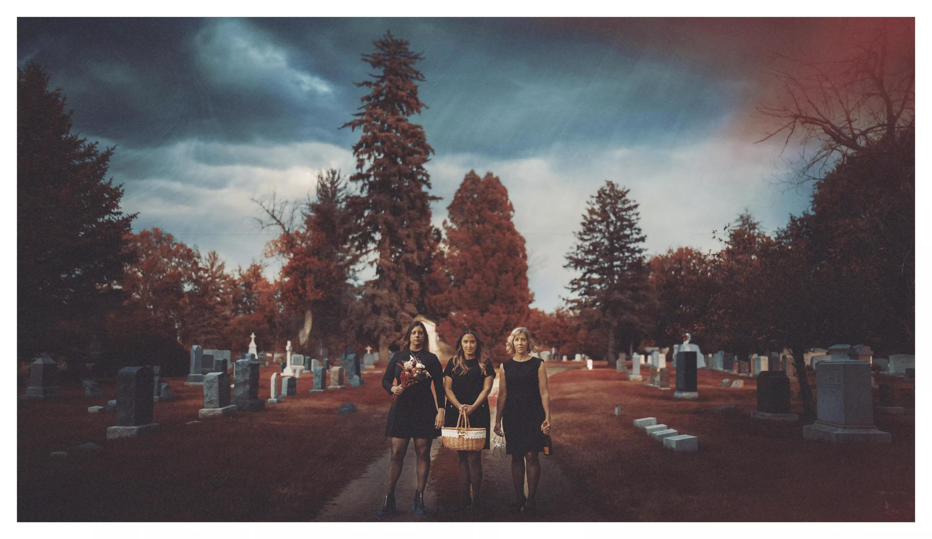 Three women walk together outside.