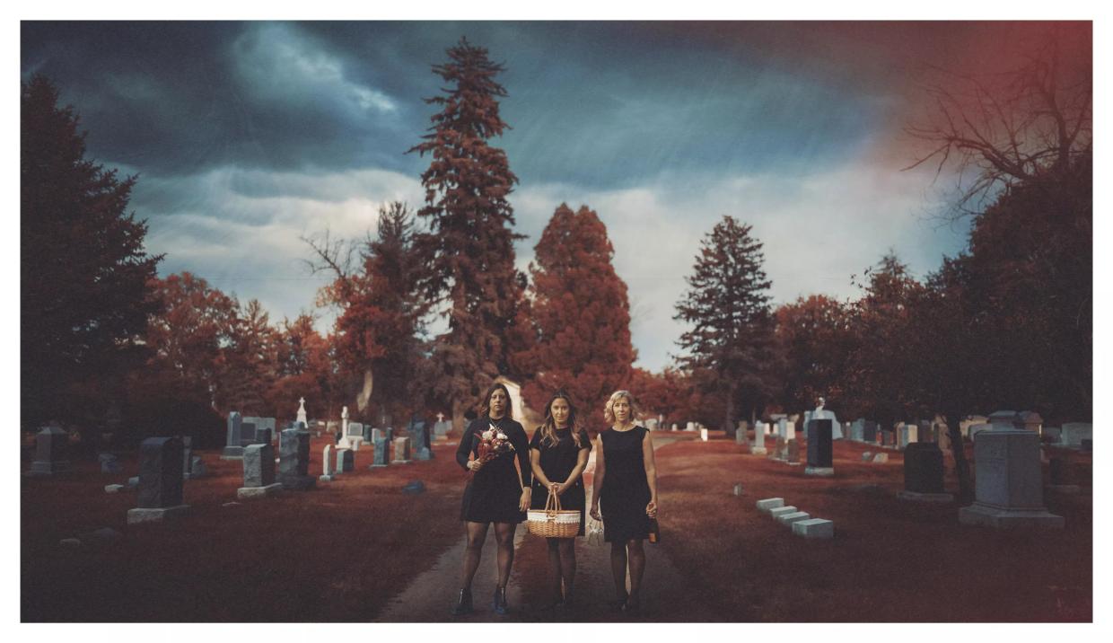 Three women walk together outside.