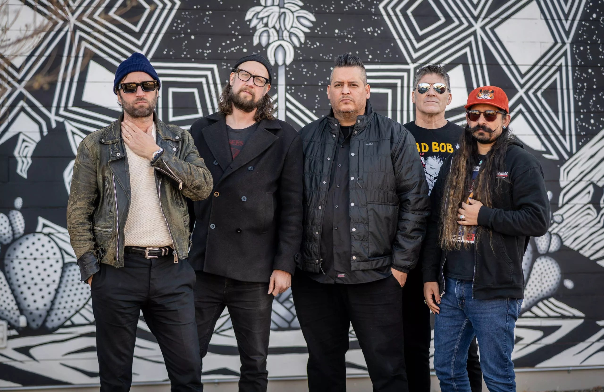 Five men standing against a wall.