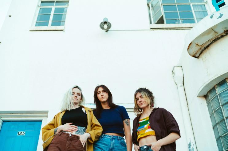 three women in front of a white building