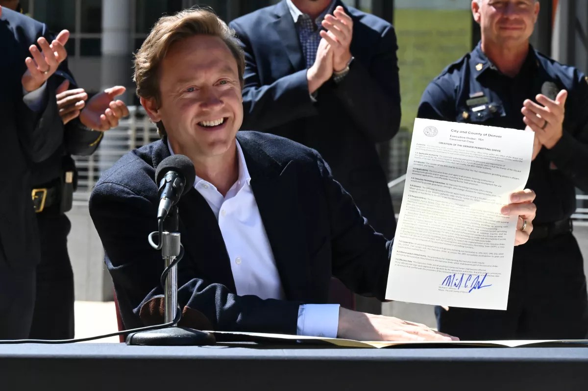 A man smiles with paper.
