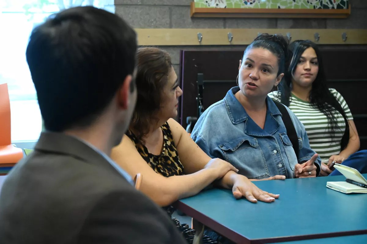 A woman speaks to someone at her table.