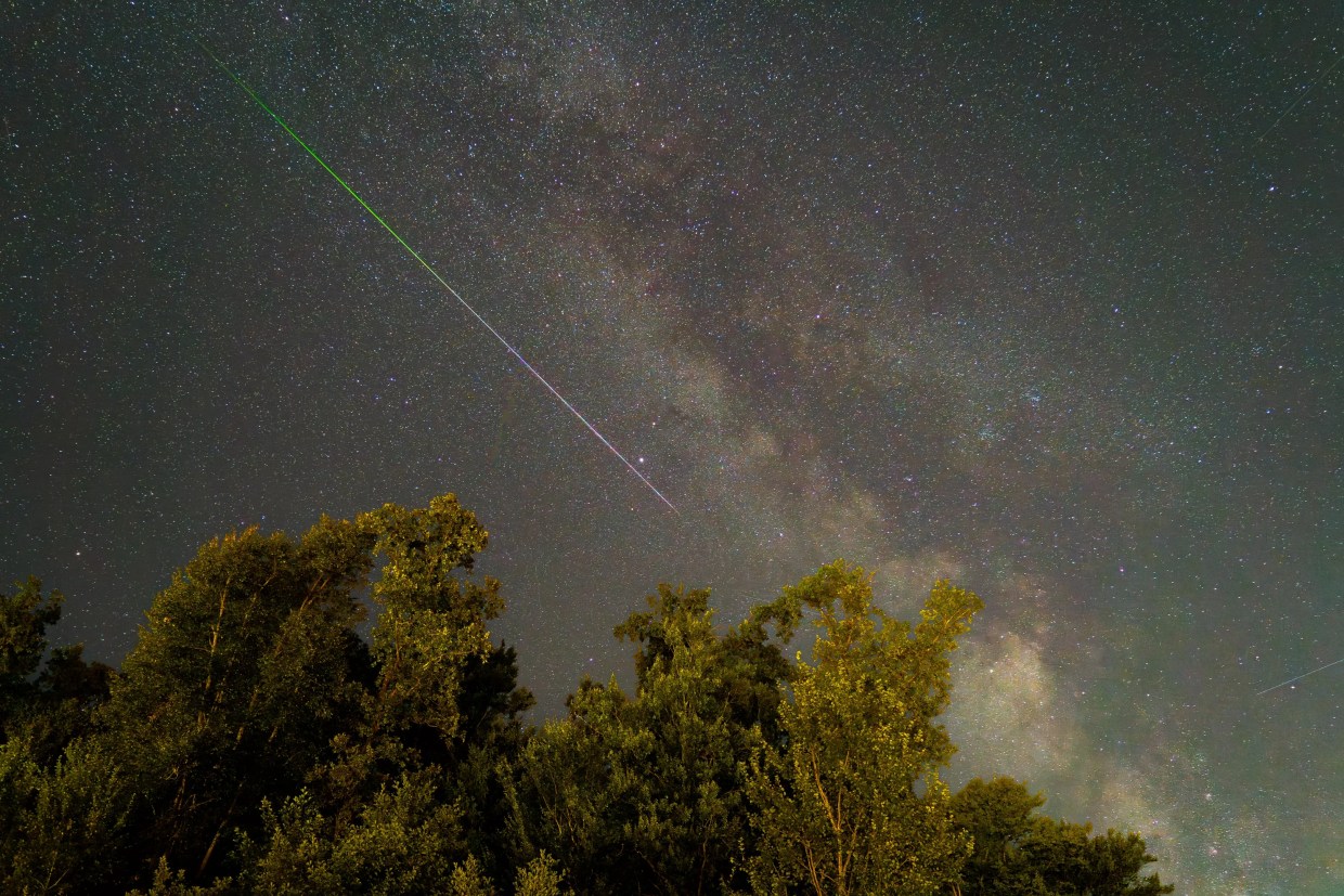 A shooting star streaks across the sky