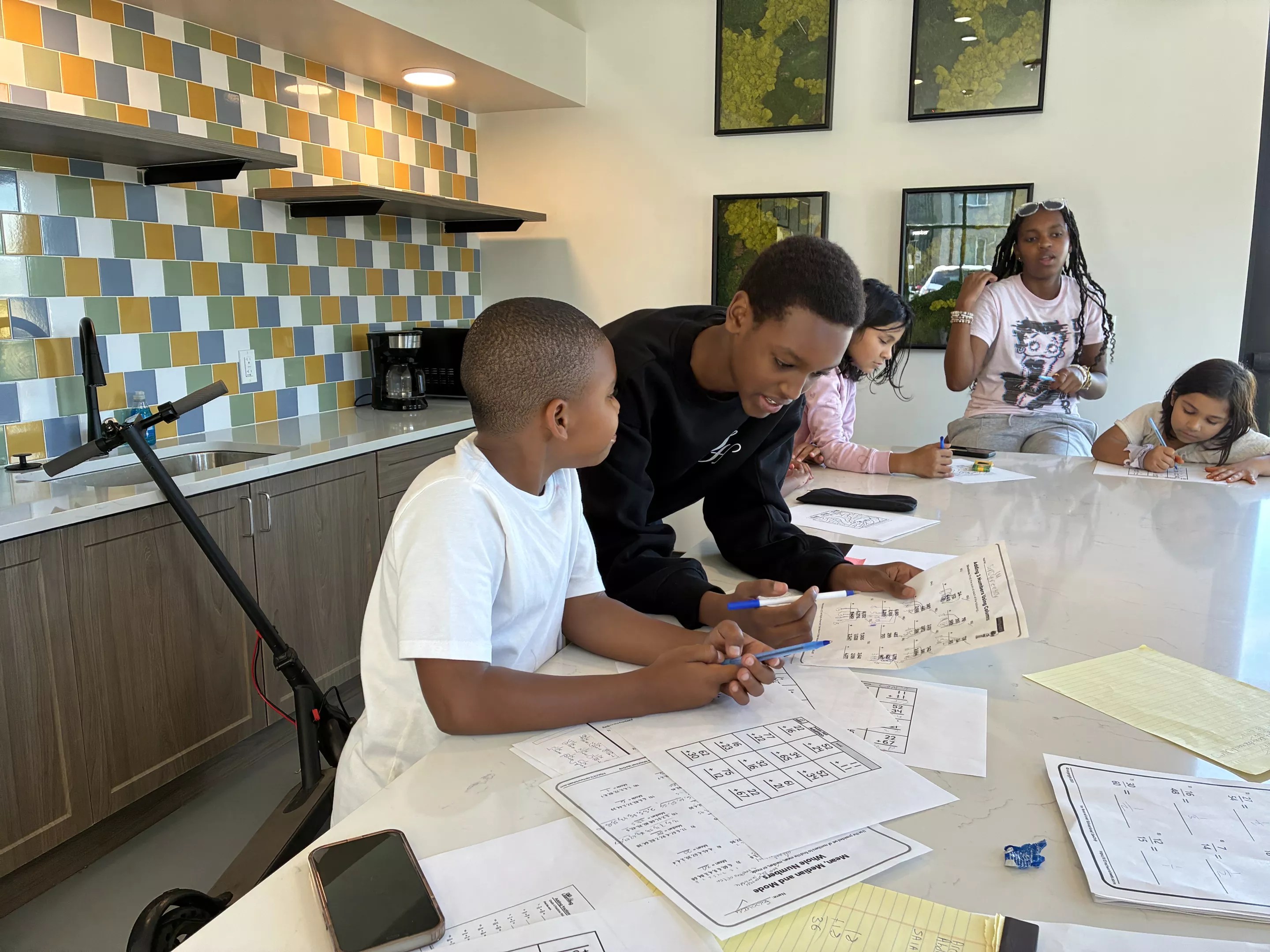 A teenager tutors a younger kid.