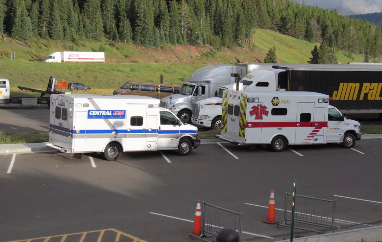 two ambulances parked in front of trees in the Colorado mountains